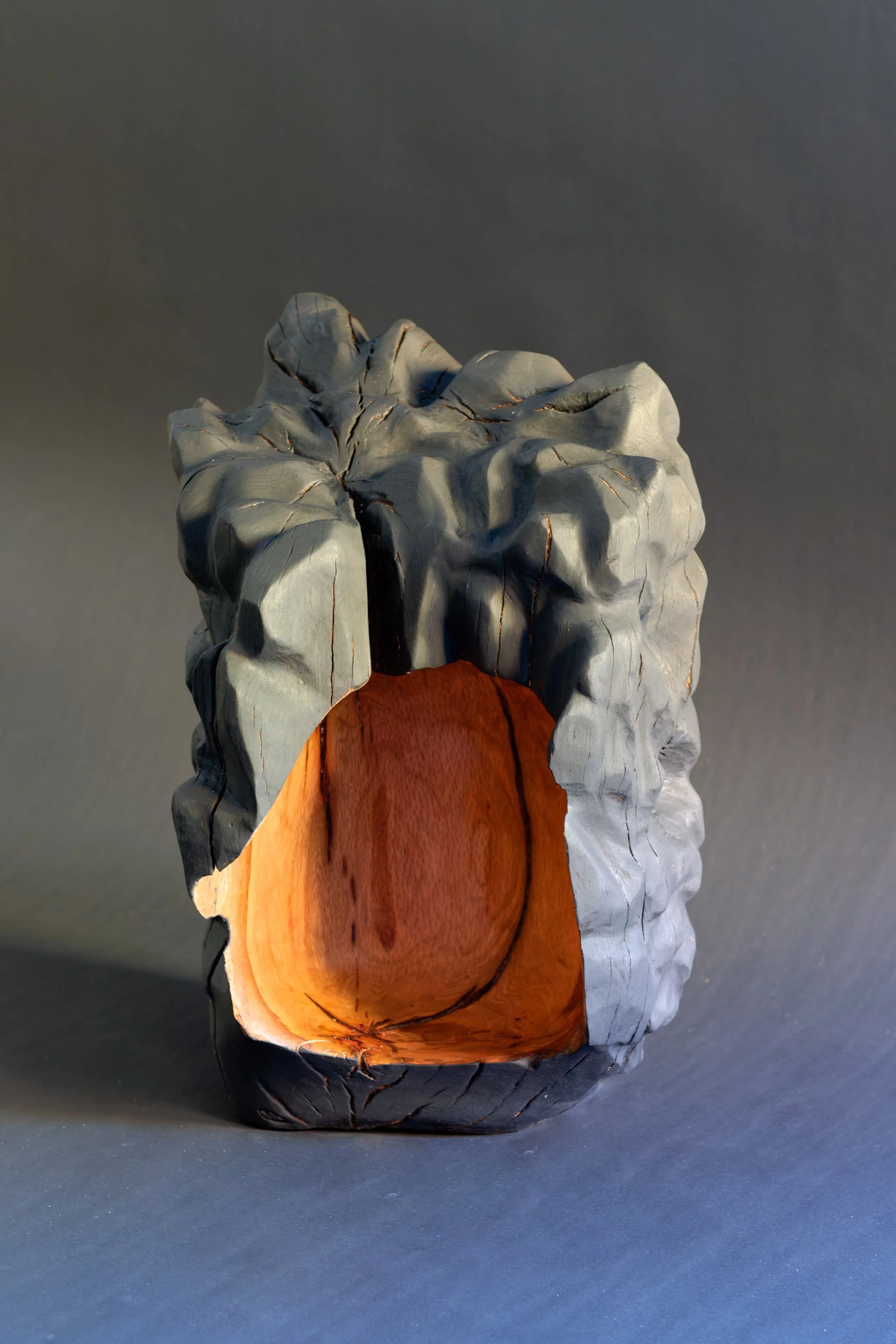 Dear Child, Safe Space — a rough grey carved shell sheltering a smooth orange form.