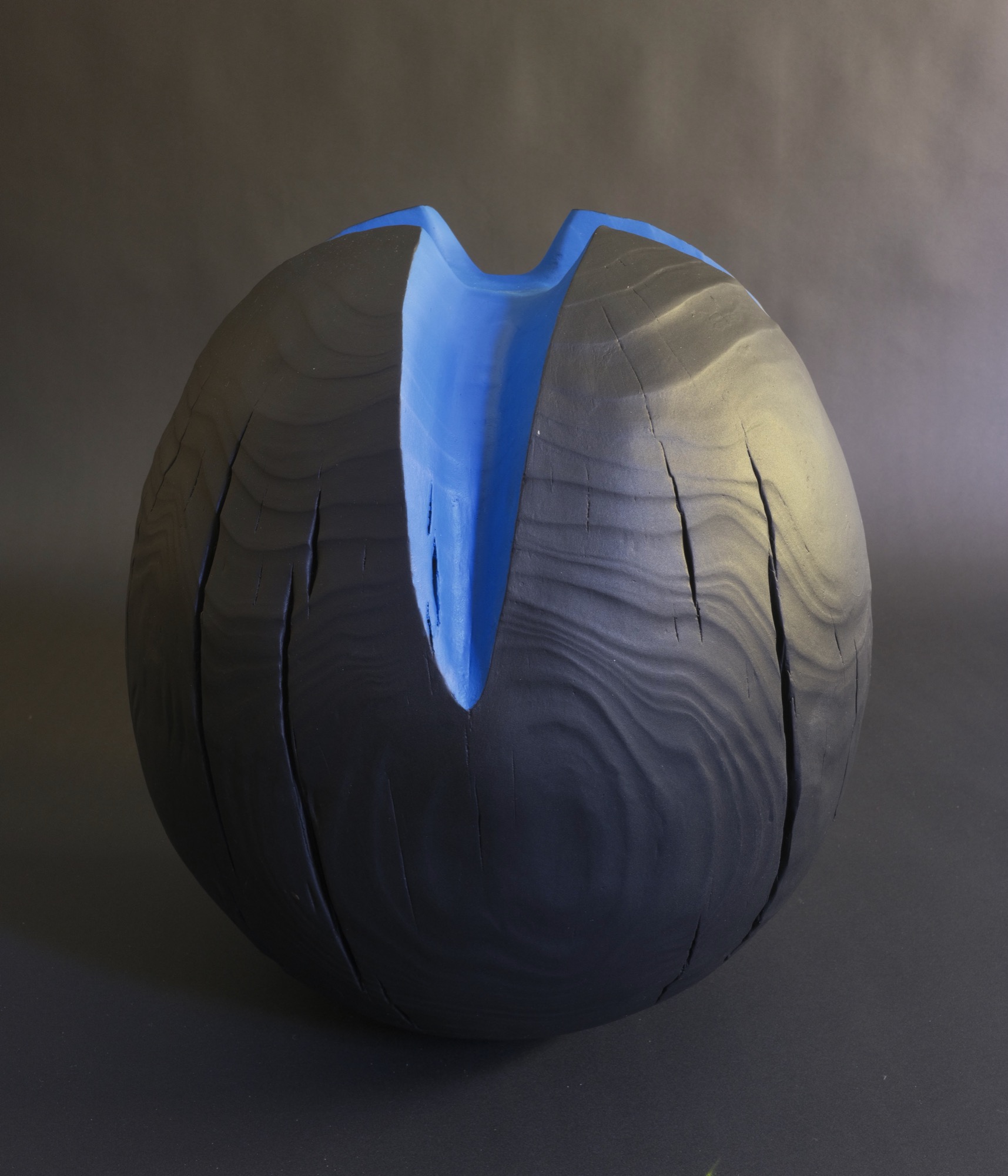 It was tiime to leave — a charred black sphere split by a vivid cobalt-blue cleft.